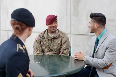 Member of the military talking to two people 