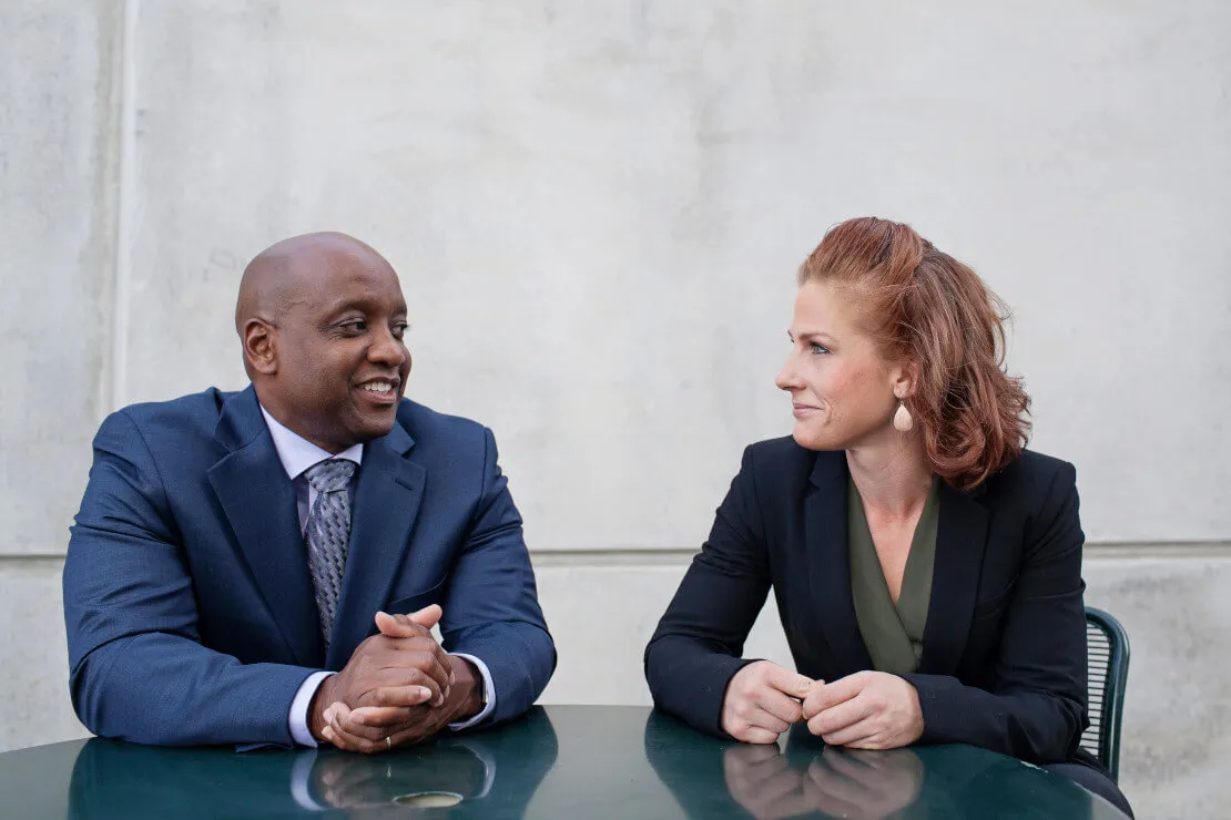 Two Boots to Suits members talking at a table. 